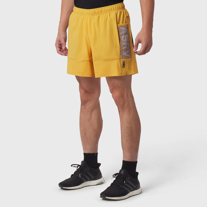 Tetra-Lite® Adventure Short in amber yellow, worn by model with black socks and sneakers