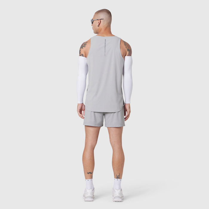Aerotex Perforated Run Tank in slate grey worn by model, back view with white arm sleeves