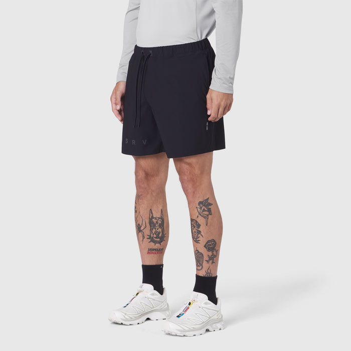 Black Revolutional Training Short worn by model with white sneakers and black socks, front view