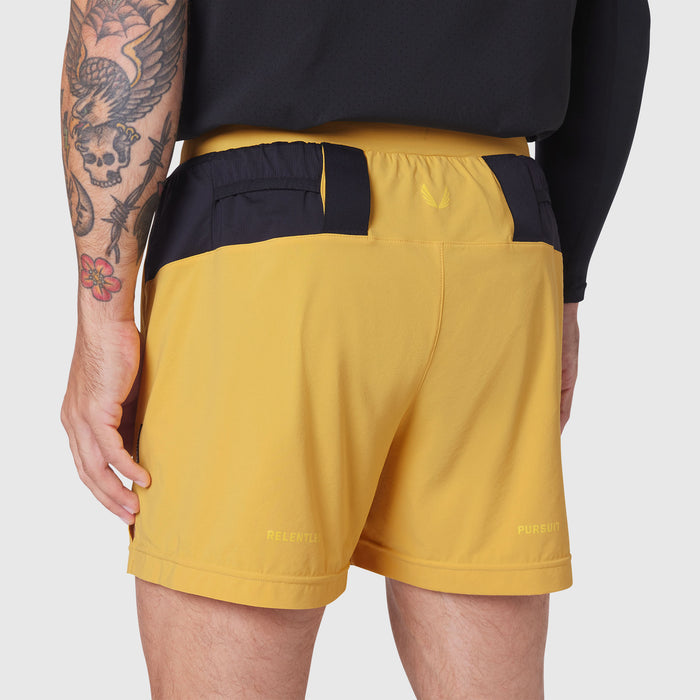 Aerotex Distance Run Short in amber yellow, back view on model with tattoos