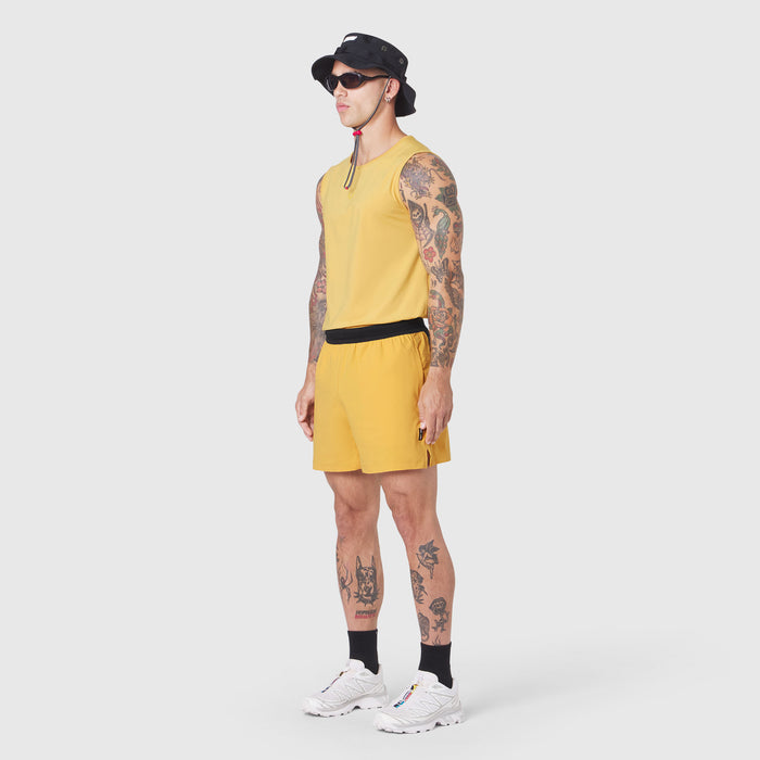 Tetra-Lite 5" Linerless Training Short in amber, worn by model with tank top and sneakers, side view