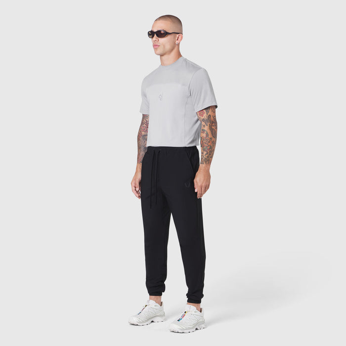 TETRA-LITE® Training Jogger in black, worn with grey t-shirt and white sneakers, full-length side view