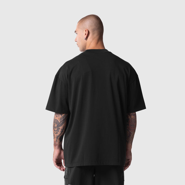 Model wearing black Tech Essential™ Oversized Boxy Tee, rear view showing back fit and oversized silhouette.