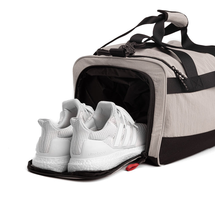 Flatlay 1234 Ripstop Duffle Bag in Chai with white sneakers in shoe compartment