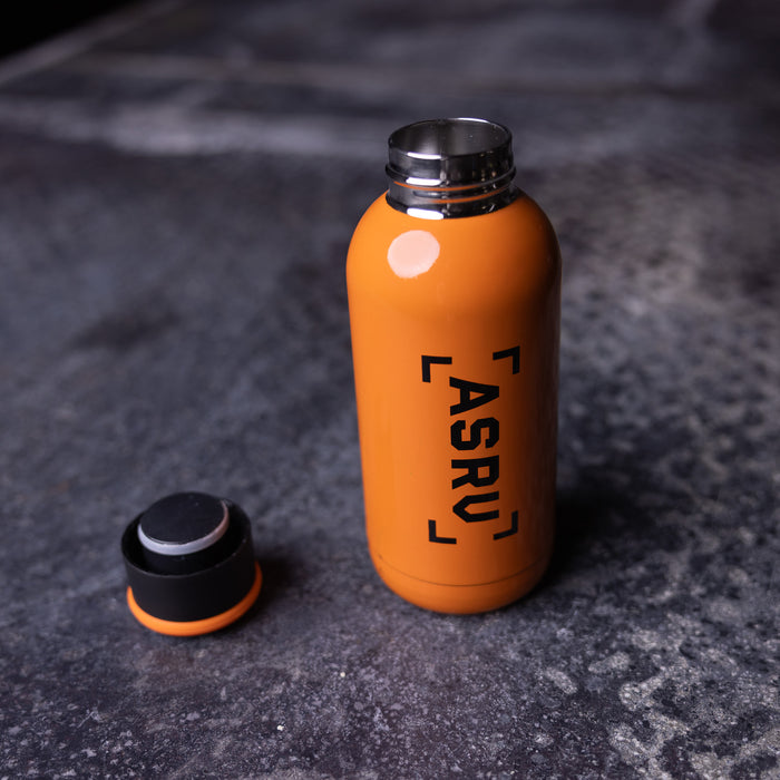 flatlay ASRV 2017 Training Division Water Bottle in orange, overhead view with cap removed