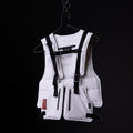 White technical vest with black straps and harness system displayed on hanger against black background