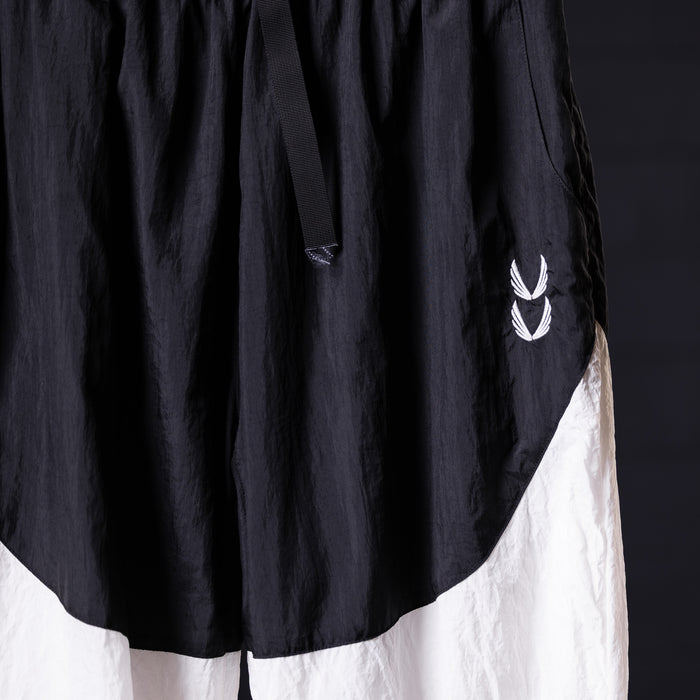 Oversized track pant in black and white, worn on model, showing side detail and branding