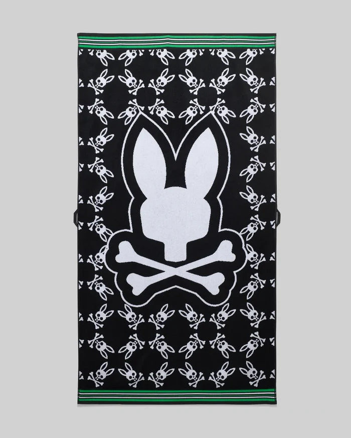 Mens All Over Bunny Towel in black terry cloth, featuring a large white central Psycho Bunny skull logo and an all-over pattern of smaller white bunny skulls, finished with green and white striped borders.