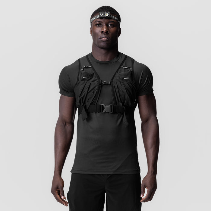 Black tactical vest worn over charcoal t-shirt with headband, front view