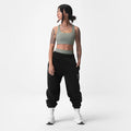 Sage Lycra® Hybrid Sports Bra worn with black joggers, front view on model