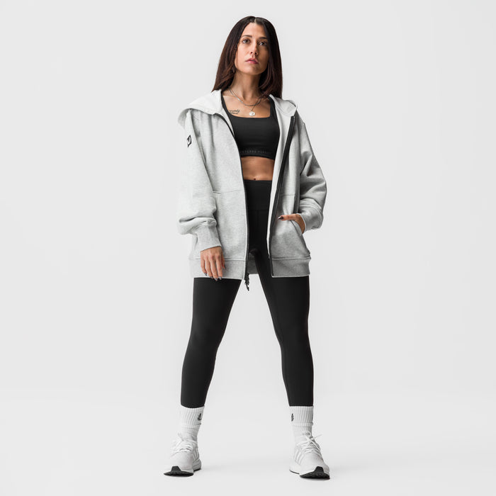 Heather grey oversized zip hoodie worn with black sports bra and leggings, white socks and sneakers
