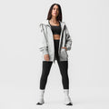Heather grey oversized zip hoodie worn with black sports bra and leggings, white socks and sneakers