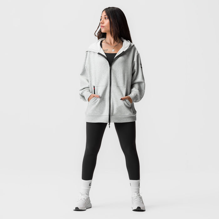 Heather grey oversized zip hoodie worn with black leggings and white socks, front view