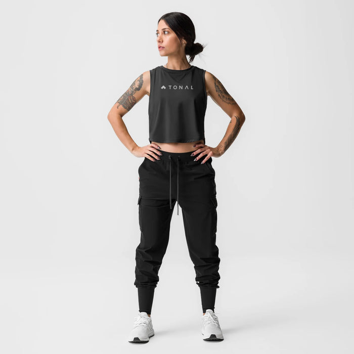 Black cropped training tank with TONAL branding, worn with black joggers and white sneakers