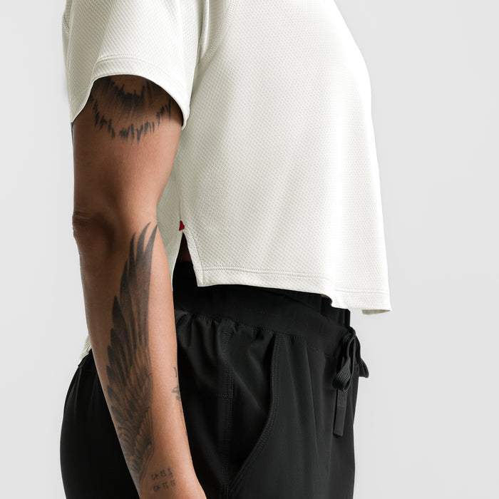 Ivory cream cropped training tee worn by model showing side view and fit