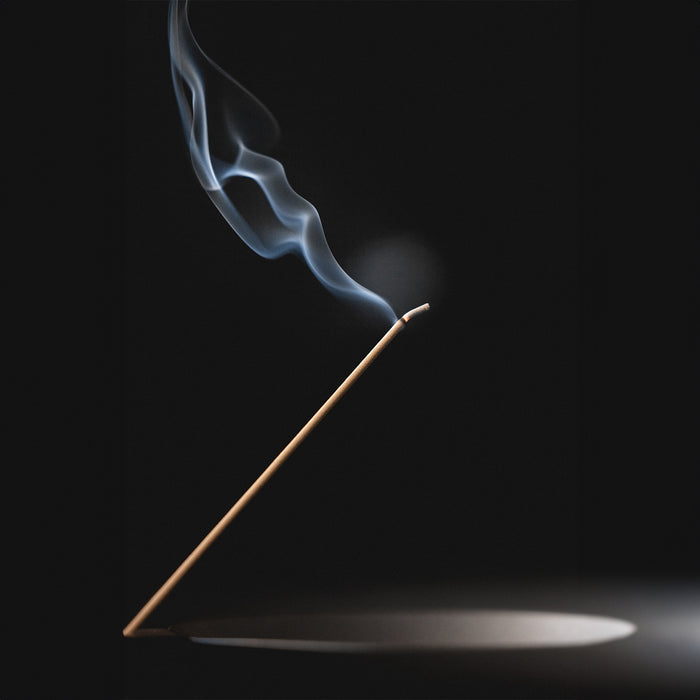 ASRV x Walden Block Incense Holder flatlay, wooden stick with blue smoke against dark background