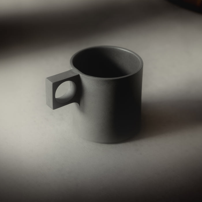 flatlay ASRV x Walden ceramic mug in charcoal grey, angled view