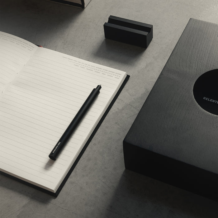 flatlay ASRV x Walden Magnetic Pen & Stand in black, overhead view with notebook