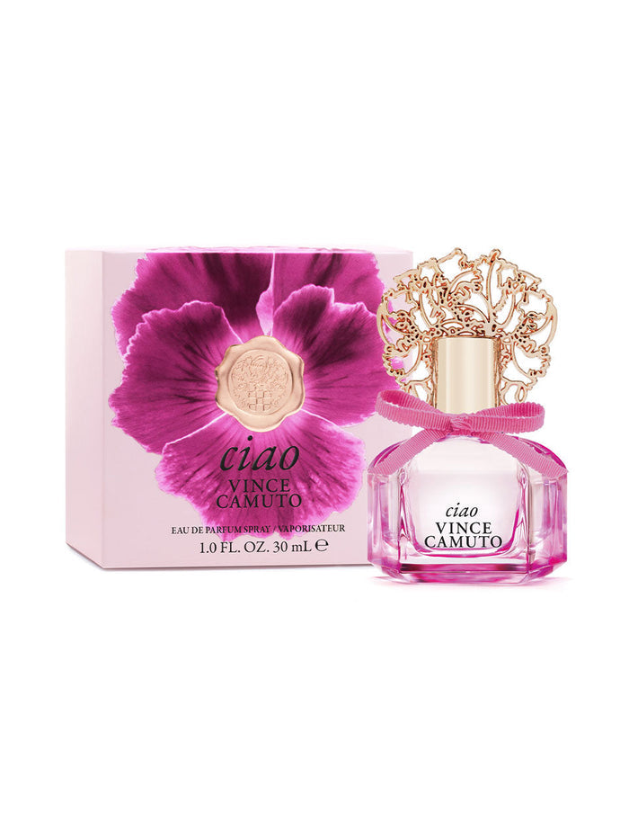 A 1.0 oz bottle of Ciao Eau de Parfum Spray by Vince Camuto, adorned with an ornate gold cap and a pink bow, comes in a matching box featuring a bold pink flower. Both the bottle label and the box display the product name and size. The fragrance captures the essence of the Mediterranean sea with vibrant citrus notes.