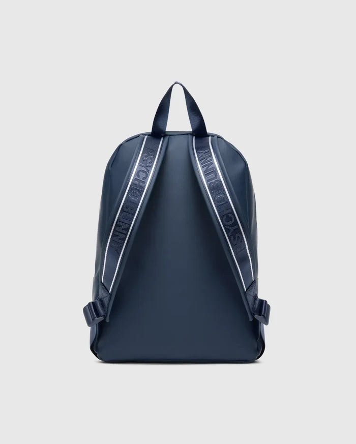Classic Bunny Backpack in navy blue with a smooth, matte finish, featuring white and light blue striped webbing with repeated Psycho Bunny text branding on the adjustable shoulder straps.