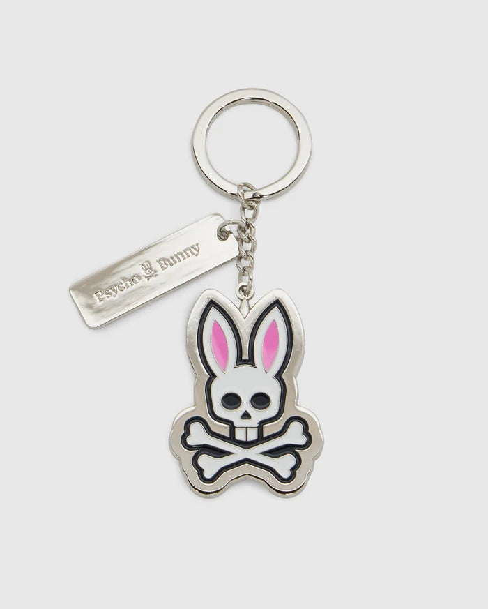 Introducing the CLASSIC BUNNY KEYCHAIN - B6A372E200 from Psycho Bunny, a fashionable metal accessory showcasing a cartoon bunny skull and crossbones design with distinctive pink ears. This practical everyday keychain features a sleek rectangular tag engraved with "Psycho Bunny." Complemented by a silver-colored chain and keyring, it adds a chic touch to your essentials.