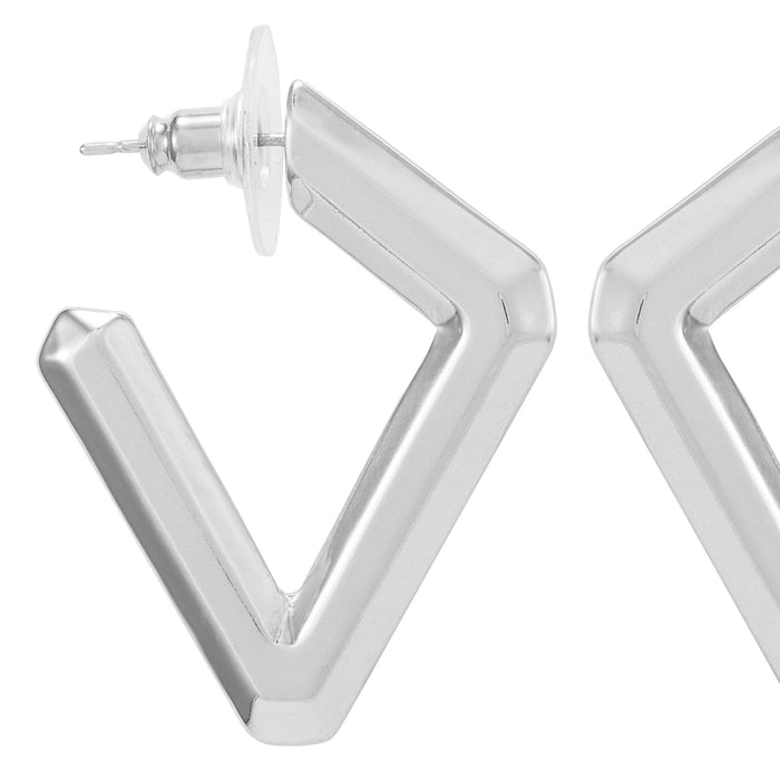 Close-up of a shiny, silver Diamond Shaped Hoop Earring by Vince Camuto with a V-shaped design and clear backing, set against a white background. Only one earring is fully visible while the other is partially shown—a modern chic accessory reminiscent of geometric statement pieces.