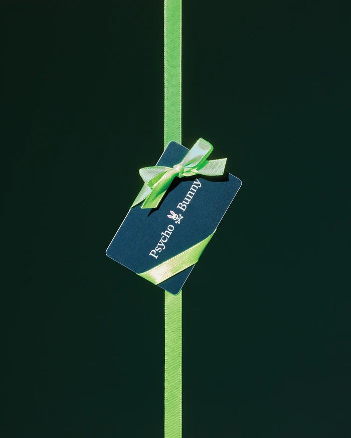 Psycho Bunny Digital Gift Card, a dark blue card featuring the iconic white bunny skull logo and brand name, elegantly wrapped with a vibrant lime green ribbon and bow.