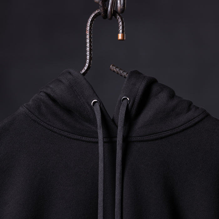 FA'20 Contrast Thread Hoodie in black, hung on metal hook showing drawstring detail