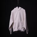 Tech Terry Eagle Hoodie in cream, displayed on hanger against black background