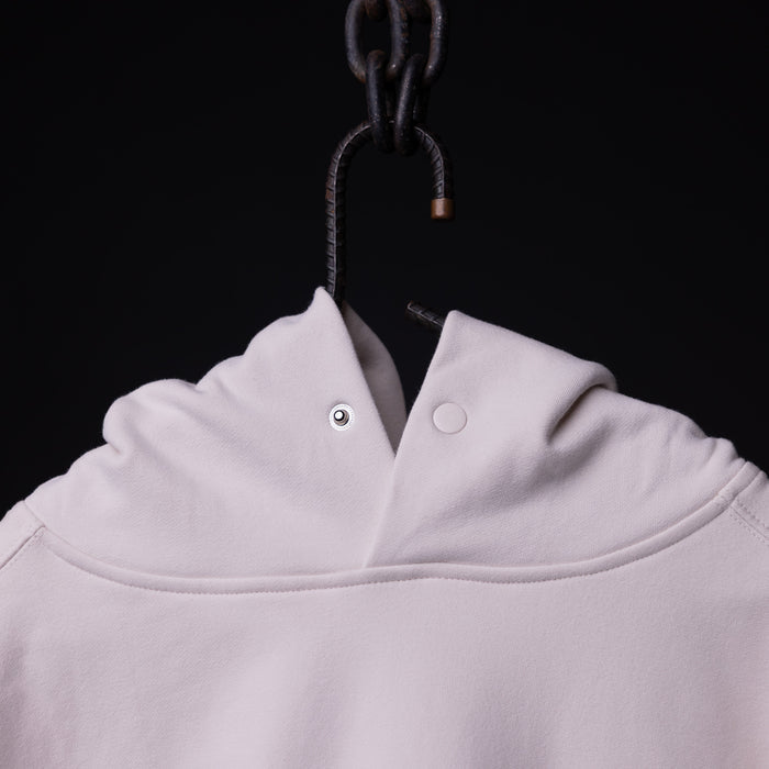 Tech Terry Eagle Hoodie in white, hung on dark hook showing collar detail
