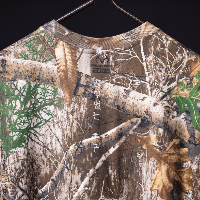 flatlay FA'23 Rocker Cutoff tee in tan with forest and birch tree graphic print, front view