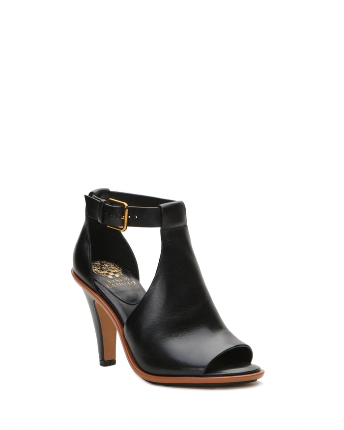 The Frasper Shootie by Vince Camuto is a black leather peep-toe high heel with an ankle strap and gold buckle, featuring a cutout design, cushioned footbed, and mid-height stiletto heel, displayed against a plain white background.