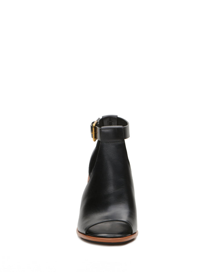 Front view of the Vince Camuto Frasper Shootie—a black leather peep-toe sandal ankle boot featuring a side buckle and cushioned footbed—set against a plain white background.