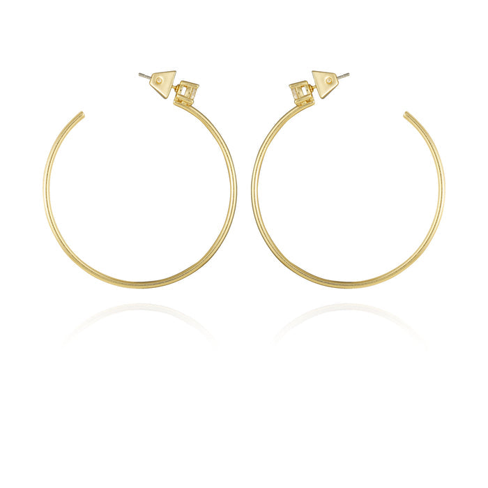 A pair of Vince Camuto Goldtone Cubic Zirconia Open Hoop Earrings, featuring large, thin gold hoops with geometric stud backs, displayed on a white background with a subtle reflection beneath.