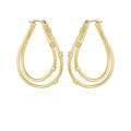 Goldtone Double Oval Hoop Earrings by Vince Camuto, featuring double curved bands and small round crystal stations, displayed on a white background for a chic and elegant look.