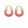 The Vince Camuto Goldtone Pink Candy Hoop Earrings feature thick, rounded pink resin hoops topped with gold-tone pointed caps, displayed on a white background.