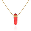 The Vince Camuto Goldtone Red Crystal-Shape Stone Pendant Long Necklace features a dazzling faceted red stone accented by gold bands, displayed on a white background—a striking statement piece with a long box chain for added elegance.