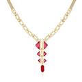 The Vince Camuto Goldtone Red Stone Pendant Statement Necklace showcases a modern, symmetrical design with a geometric snake chain and four vertically graduated red resin stone pendants set in gold. The striking, bold necklace is photographed against a white background for an eye-catching presentation.