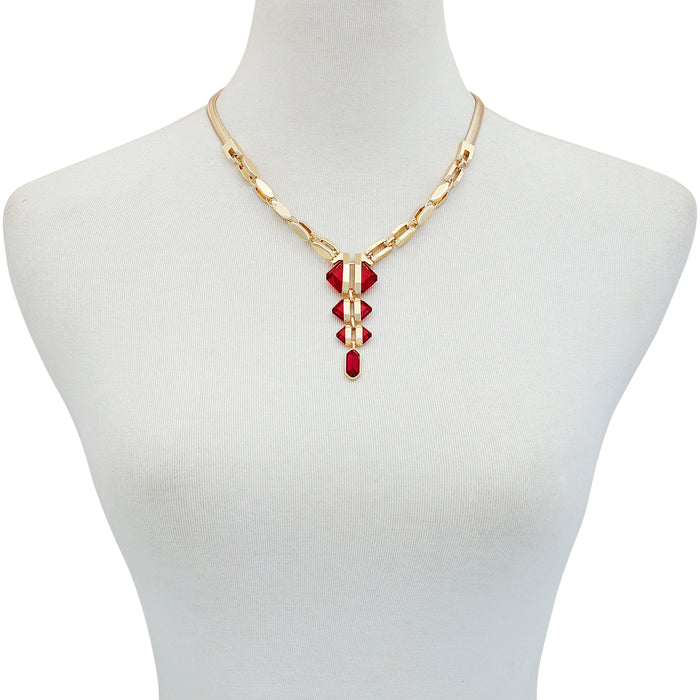 The Vince Camuto Goldtone Red Stone Pendant Statement Necklace features a unique geometric pendant adorned with five striking red resin stones on a classic gold snake chain, elegantly displayed on a white mannequin bust—an eye-catching statement piece for any occasion.