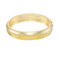 The Vince Camuto Goldtone Textured Hinge Bracelet features an intricate textured design with beaded details and a secure hinged closure, beautifully displayed on a white background.