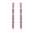The Goldtone Violet Stone Baguette Stick Drop Earrings by Vince Camuto feature a modern linear design with a vertical row of baguette-cut purple stones, elegantly displayed on a white background.
