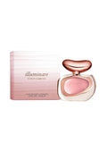 A 1.0 oz bottle of Vince Camuto Illuminare Eau de Parfum, featuring a pink liquid and a distinctive gold and pink cap, is displayed next to its elegant pink gradient box. The luxurious ambery musk fragrance comes in sophisticated packaging, with the box clearly showing the Vince Camuto name and product size.