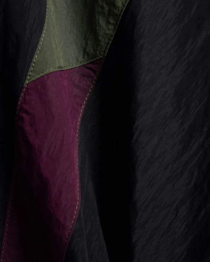 Kids Alder Nylon Colorblock Pant featuring crinkled black nylon with bold olive green and deep magenta colorblock panels, accented by prominent light yellow stitching.