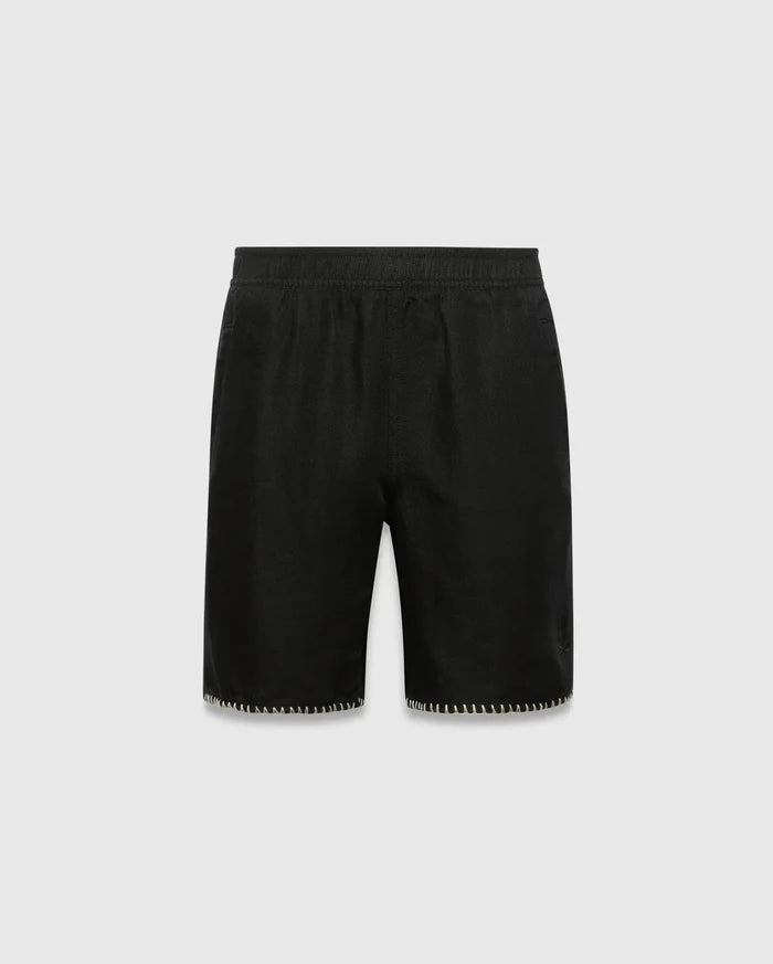 Kids Brad Linen Short, black relaxed fit with linen texture, featuring a subtle tonal embroidered Psycho Bunny skull logo on the lower right leg and white contrast blanket stitching on the hem.