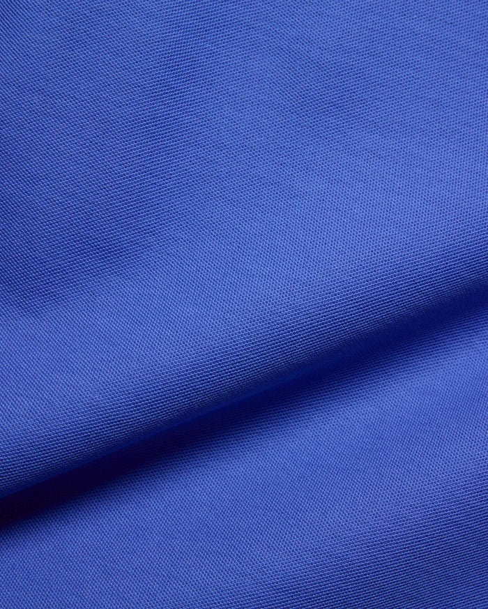 Kids Brad Pique Polo, a vibrant royal blue premium pique fabric, showcasing its distinctive textured weave, embodying Psycho Bunny's bold, refined streetwear aesthetic for a classic fit.