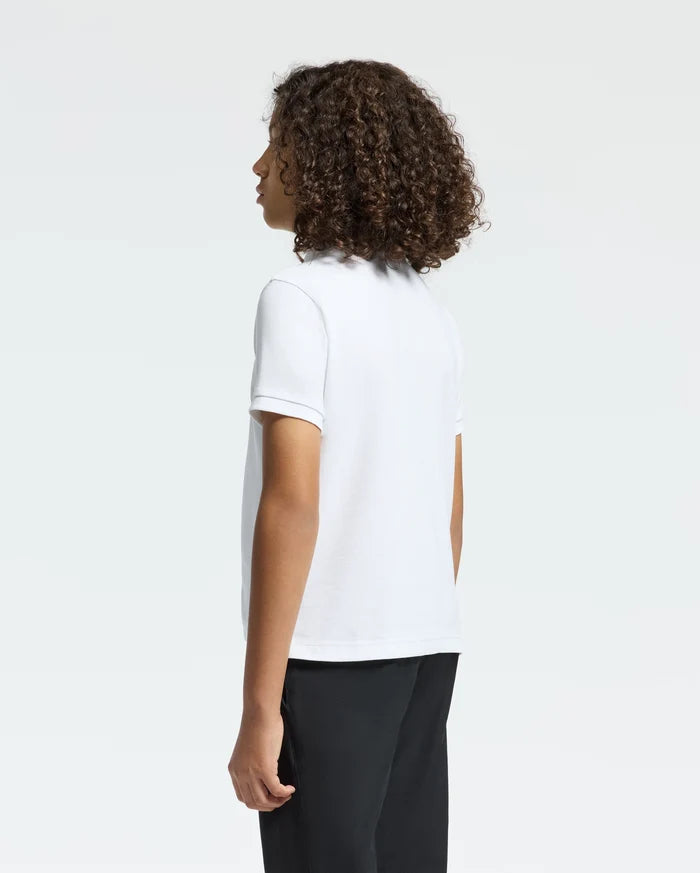 Curly-haired and facing away from the camera, a person wears a Psycho Bunny KIDS CLASSIC PIQUE POLO SHIRT in crisp white, paired with black pants, against a plain white background.