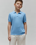Kids Devon Bubble Stitch Knit Polo in light blue, a classic fit with an open V-neck collar, ribbed cuffs, and a small embroidered Psycho Bunny skull logo on the left chest.