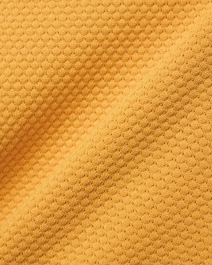 Kids Devon Knit Polo in bold golden-yellow, crafted from a premium, refined knit fabric featuring a distinctive micro-waffle texture, perfect for elevated streetwear style.