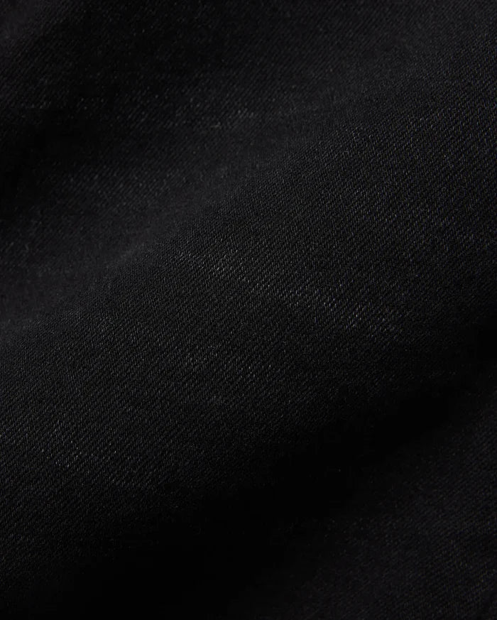 Kids Emerson Denim Pant, showcasing the rich, deep black denim fabric with a distinct diagonal twill weave texture. The premium quality material is subtly creased, highlighting its refined finish.