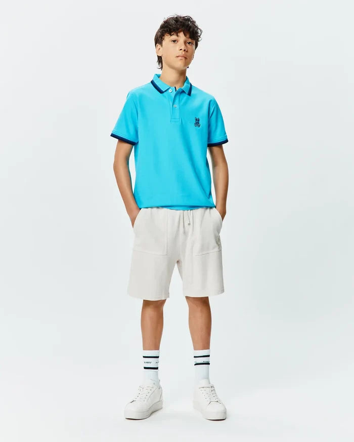 Kids Holden Pique Polo in bright blue, featuring a classic fit, pique texture, navy tipped collar and cuffs, and a small embroidered Psycho Bunny skull logo on the left chest.